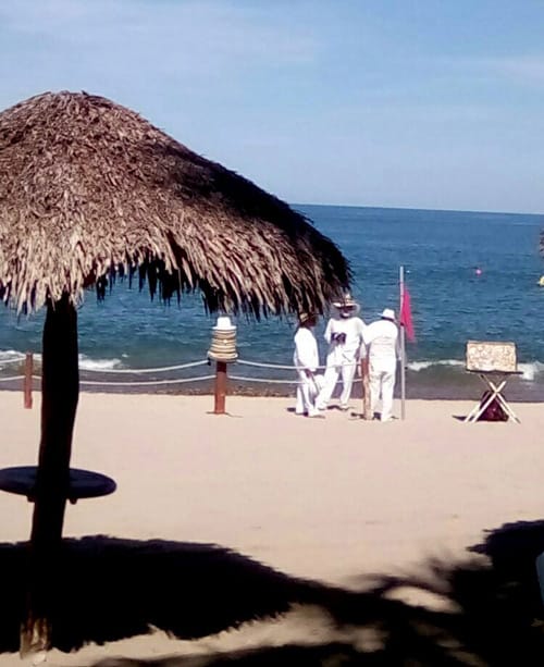 Blanket and trinket hawkers on the beach at the resort wait for tourists.