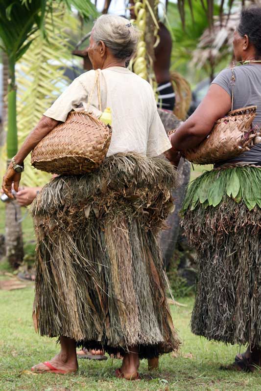 Yap women wearing traditional grass skirts and carrying handwoven baskets. Photo by Joyce McClure