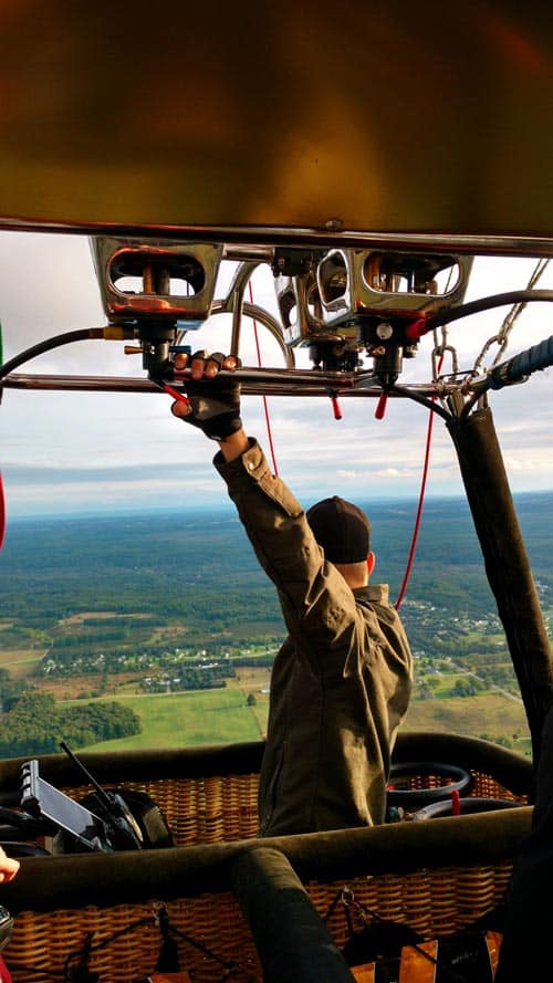 Man toggling burners in a hot air balloon in Traverse City, Michigan