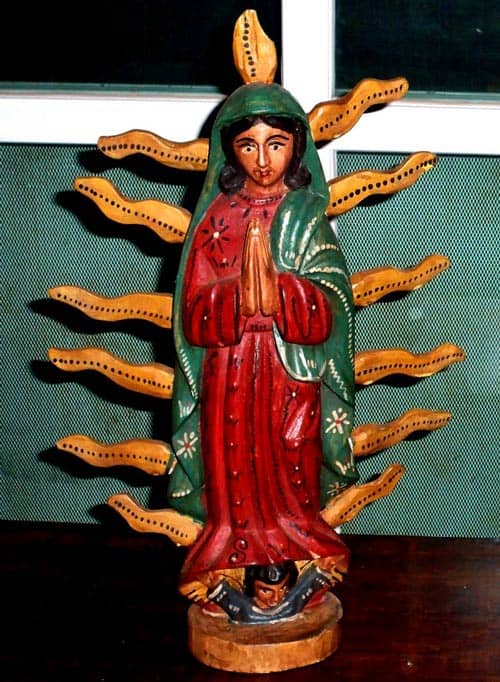 Wooden carved token of the Virgin of Guadalupe, hands praying and child below robes
