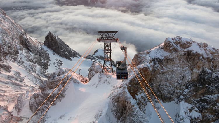 Travel by cable car up the snow-capped mountain in Germany