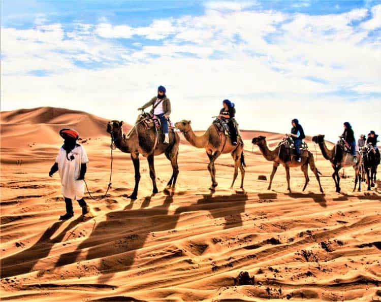 Members of an Overseas Adventure Travel Trip Riding Camels in Morocco. Photo courtesy of Grand Circle Corporation