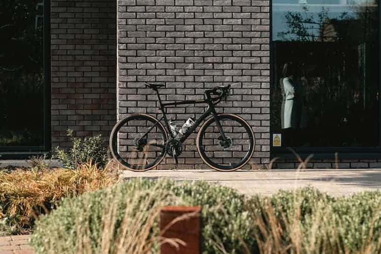 Bicycle against brick wall by Tom Austin