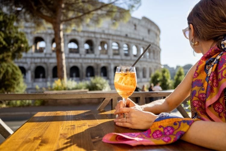 Person sitting at a cafe in front of the Colosseum in Rome