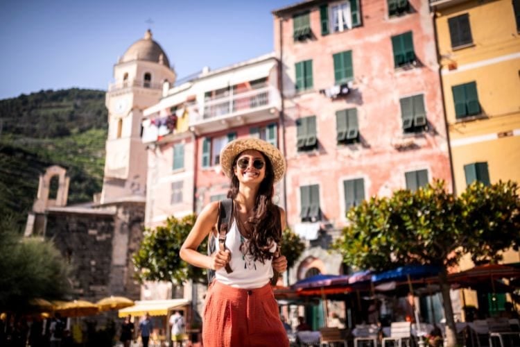 Woman smiling in front of colorful building