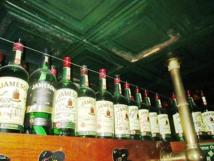 It's no accident that these liquor bottles are held in place by wires at a bar in St. Augustine known for ghostly visits. Photo by Victor Block