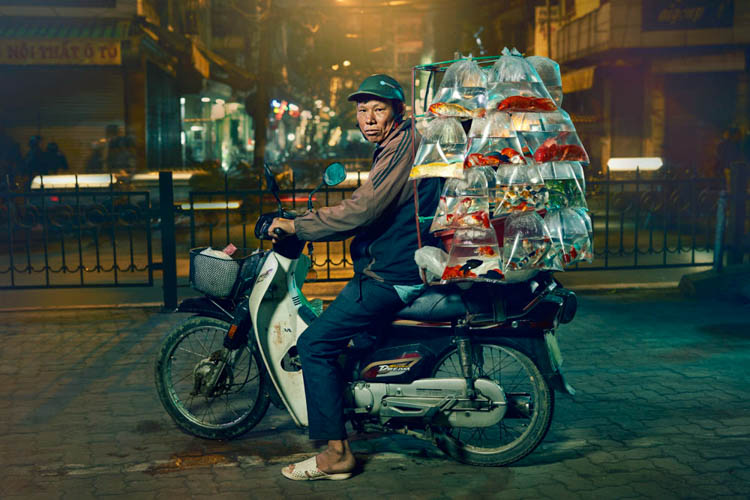 Tips untuk Fotografi Perjalanan.  Sepeda motor membawa barang di sekitar kota Hanoi, Vietnam