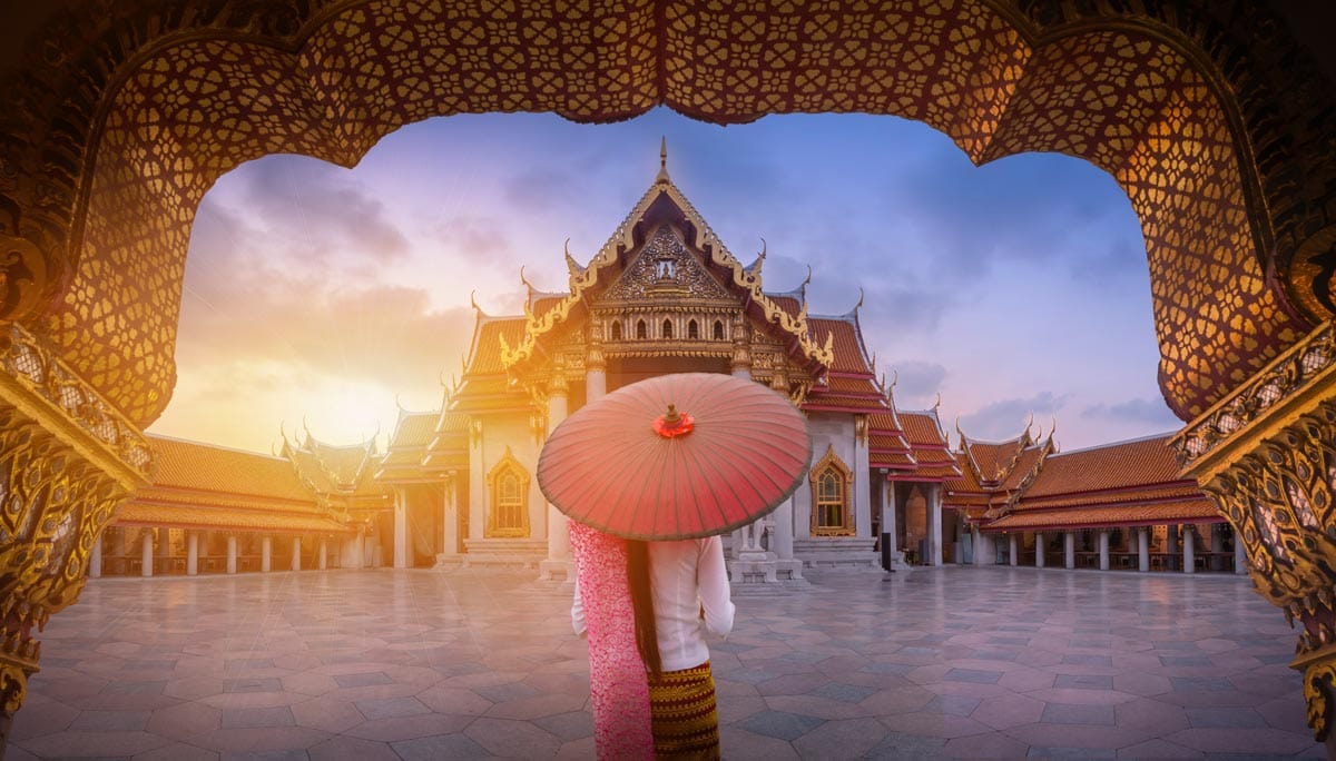  Frau mit rotem Regenschirm am Eingang zum Marmortempel, Bangkok