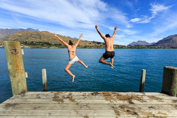 Couple jumping into a lake in Quebec. Photo by istock