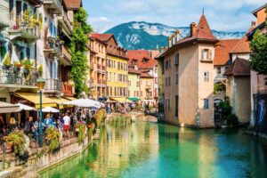 Annecy’s medieval village charms with colorful houses reflected in the calm, emerald canals—an inviting spot to explore and unwind. Photogilio via iStock