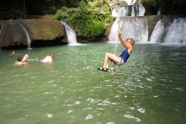 The author swinging into the waterfalls at YS Falls in Jamaica. Photo by Victor Block