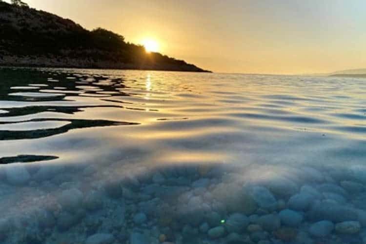 Matahari terbenam di atas air di Chios