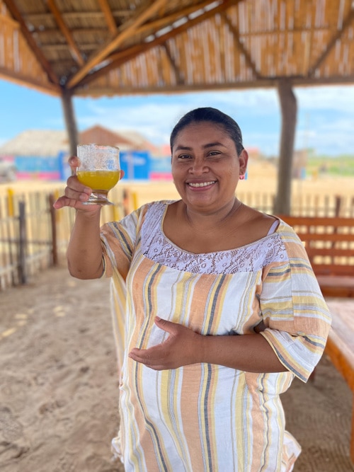Wayúu guide Gertrudis Maria holds an indigenous cocktail called a “Mitologico.