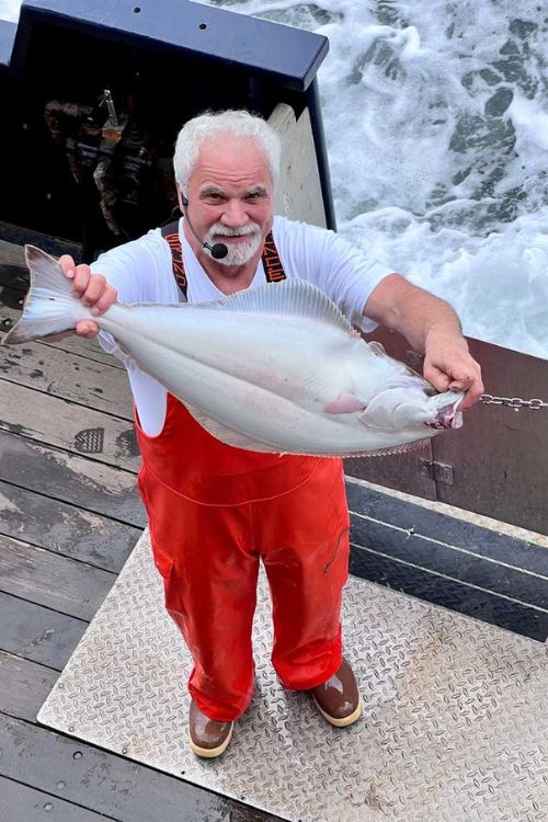 Engineer Andy Pittard shows off his catch of halibut.