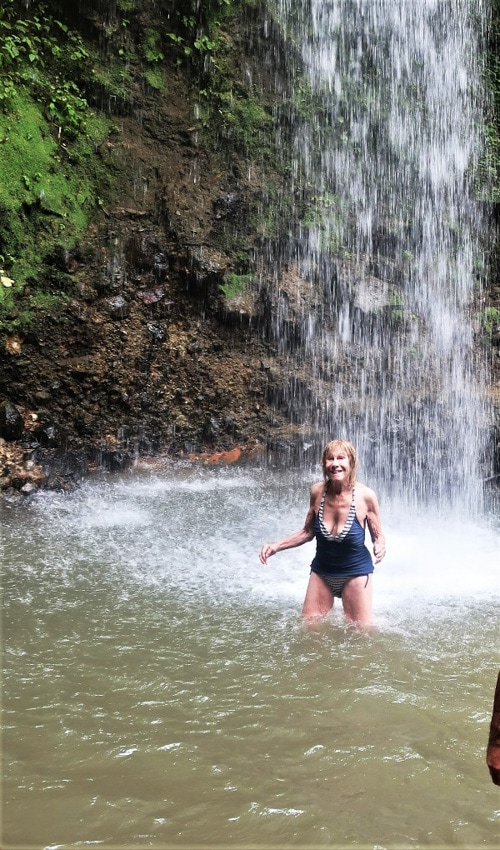 The author enjoys an exhilarating dip under a waterfall in St. Lucia