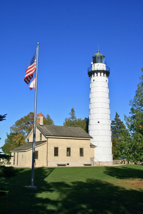 Cana Island's gleaming white tower rises high above the 1 ½ story yellow-brick keeper’s house
