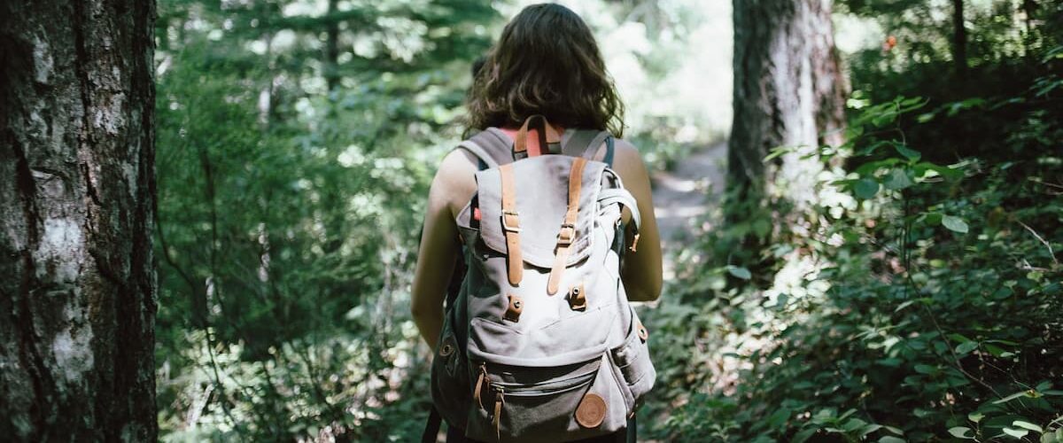 Hiker with a large backpack. Photo by Jake Melara, Unsplash