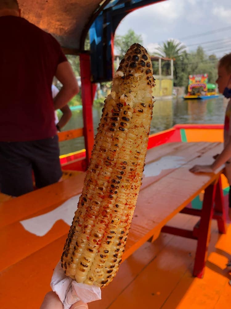 Spicy elote on a trajinera in Xochimilco. Photo by Hayley Baldwin.