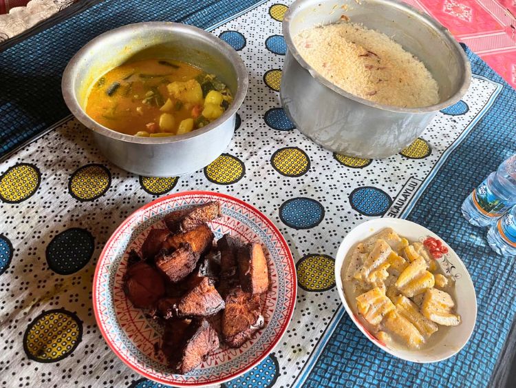 The cooked fish, rice, vegetables, and plantains with cinnamon and coconut milk