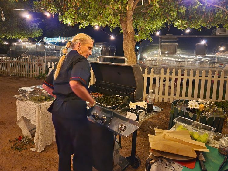 Carrie Schnepf cooks an al fresco dinner at The Cozy Peach at Schnepf Farms. Photo by Carrie Dow