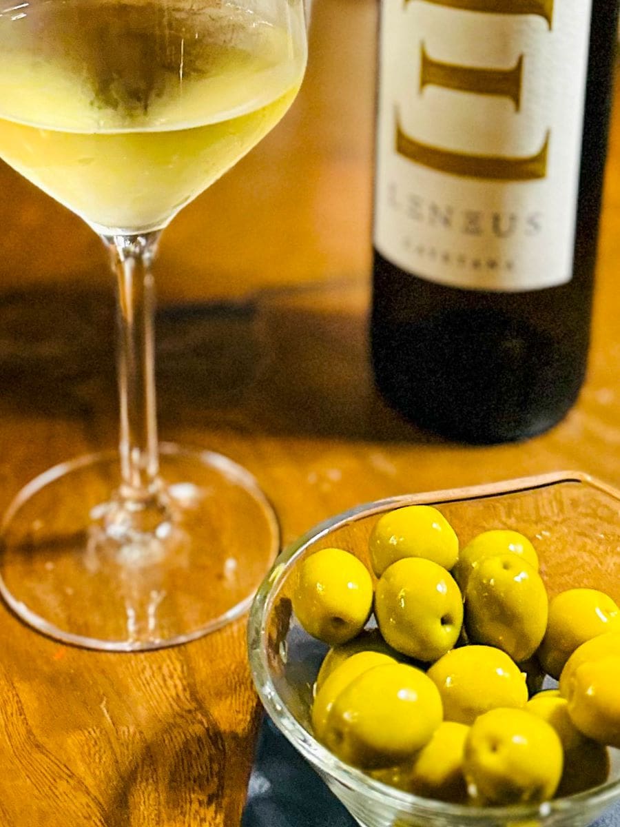 Photo of glass of wine, bottle of wine, and bowl of olives as part of the experience olive oil culture in Spain program