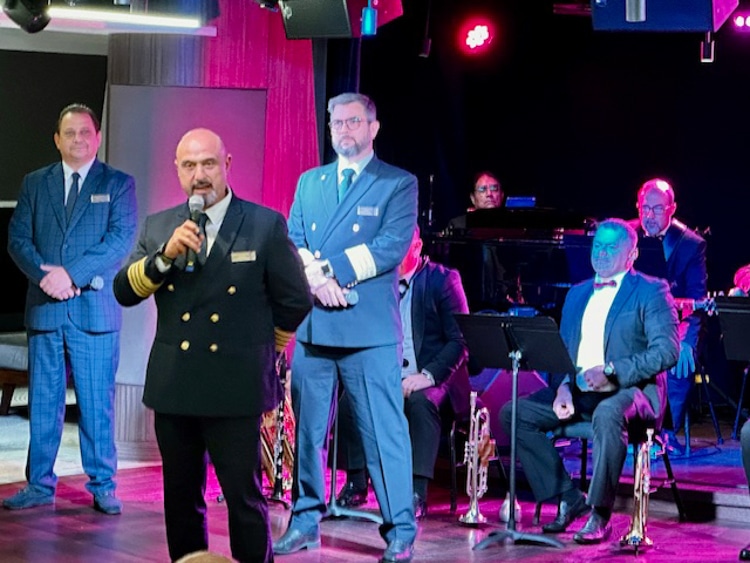 Cruise director Ray Carr, Manzi and Lacroix address passengers in front of the Vista Show Band