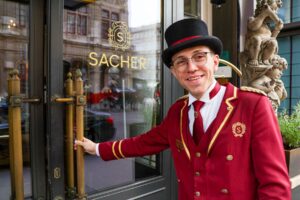 Doorman welcomes guests to Hotel Sacher, Vienna.