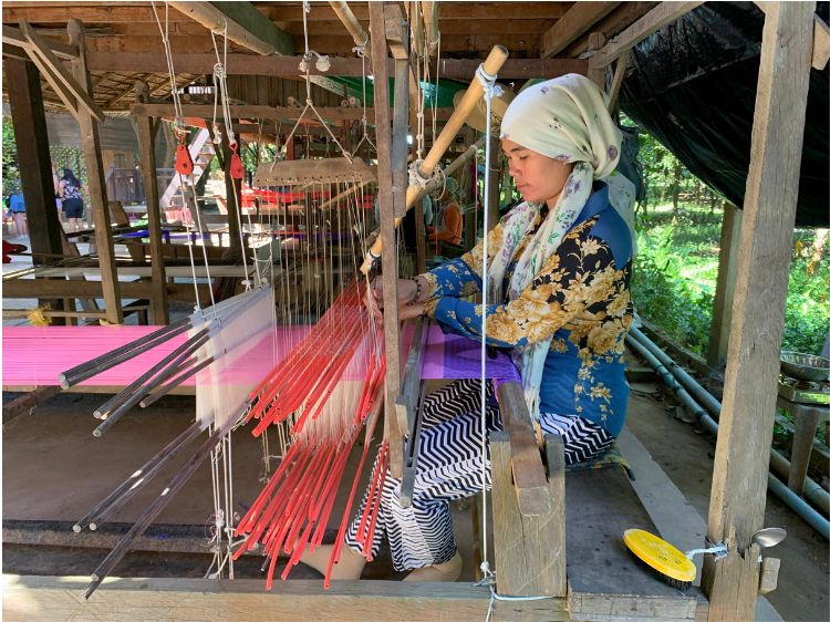 Woman silk-weaving on Silk Island. Photo by Janna
