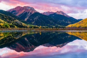 Golden hour over the San Juan Mountains captures the magic of Colorado summers—quiet trails, wildflower-filled meadows and mountain towns. Photo by Gary Gray from Getty Images Pro via Canva