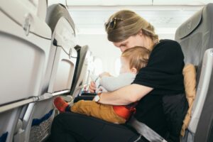 Woman with baby on plane. Photo by Paul Hanaoka, Unsplash