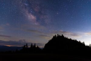 The Milky Way arches over the spruce-fir ridgeline of Western North Carolina on a clear mountain night. Photo by Joshua Moore via iStock