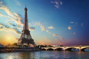 The Eiffel Tower bathes in golden sunset light—just the beginning of Paris's enchanting experiences awaiting discovery. Photo by Givaga from Getty Images Pro via Canva