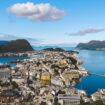 A view of the city of Ålesund, with the ocean surrounding. A bright blue sky on this day.