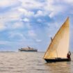 A traditional dhow sails past the cruise ship Diana off Pemba Island in the Zanzibar Archipelago
