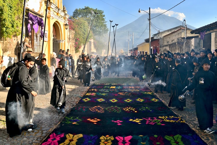 Swinging incense burners announce the procession.