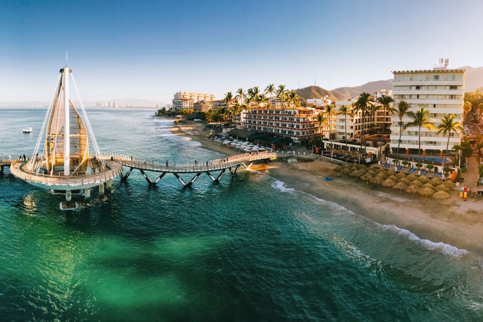 Golden beaches and turquoise waters of Puerto Vallarta's Banderas Bay, where all-inclusive resorts meet authentic Mexican culture along Mexico's Pacific Coast paradise. Photo by Canva