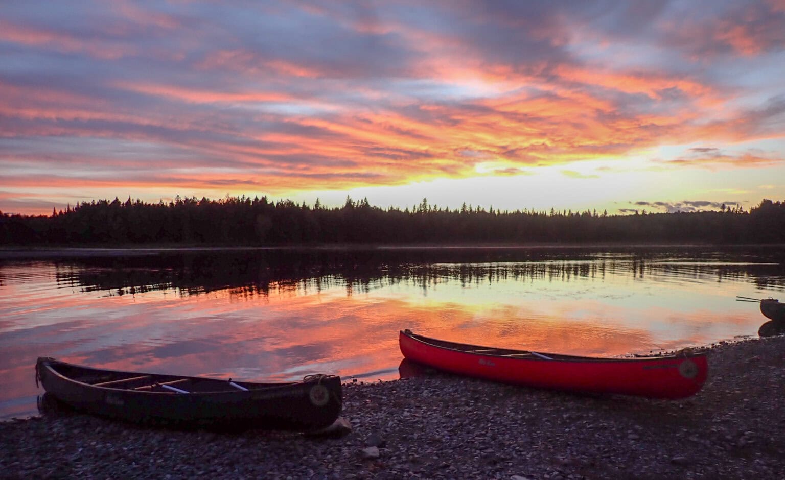 The Allagash River at sunset with canoes ready to depart in the morning. Photo by Ava Kabouchy
