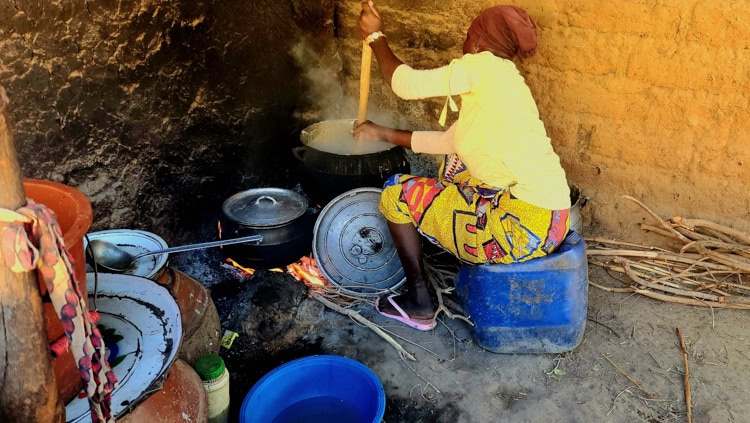 A local villager of Bougouba who invited us into her home is making millet porridge for dinner.