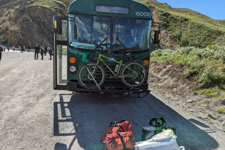 Camper bus for backpackers and bikers at mile 43 turnaround with author's bike on the front and gear on the ground