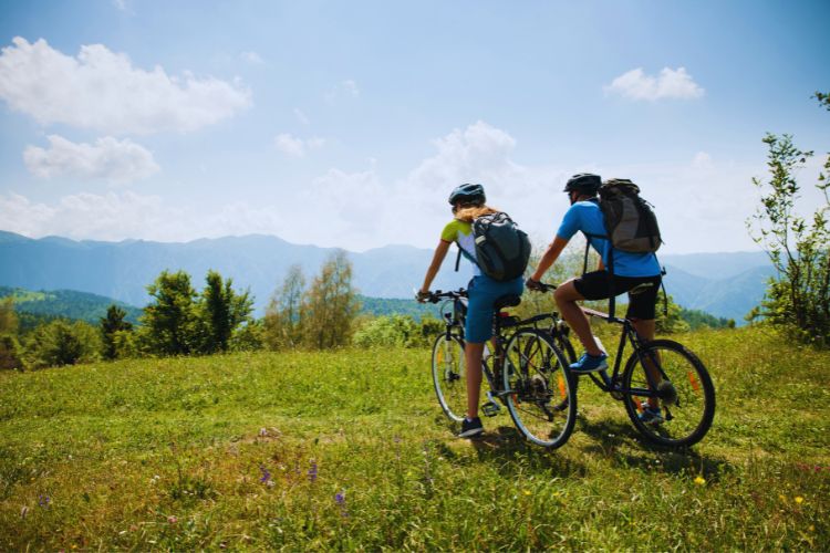 Two cyclists with small backpacks in a field