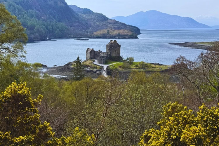 Eilean Donan Castle with mountains and water in the background