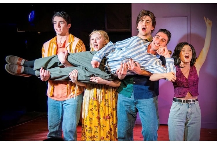 Scene from Friends! The Musical Parody, featuring actors in costume reminiscent of the original Friends TV show characters.