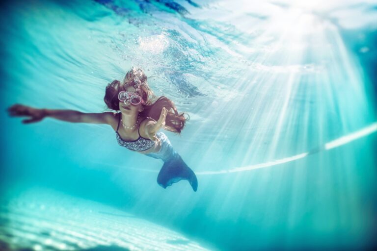 Girl with mermaid tail under water