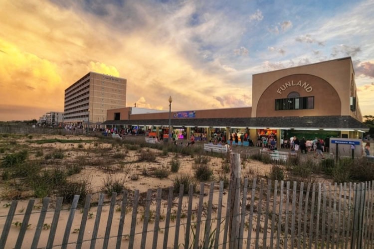 Sunset over Rehoboth Beach Boardwalk, showcasing the lively atmosphere as the day ends.