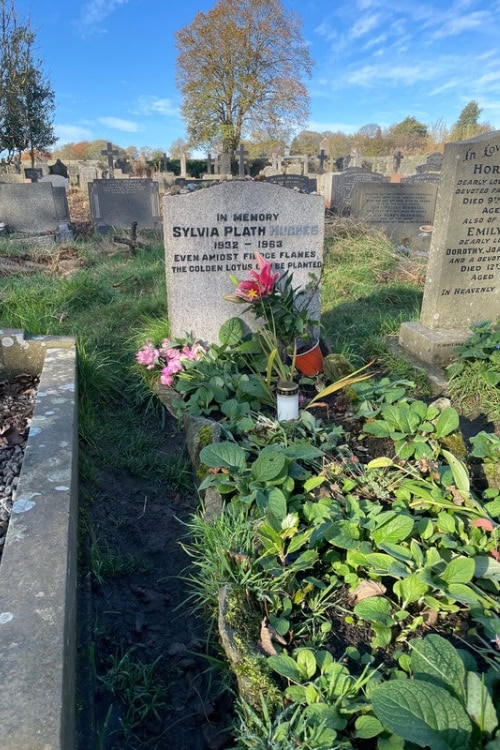 Photograph of Sylvia Plath's grave surrounded by greenery.