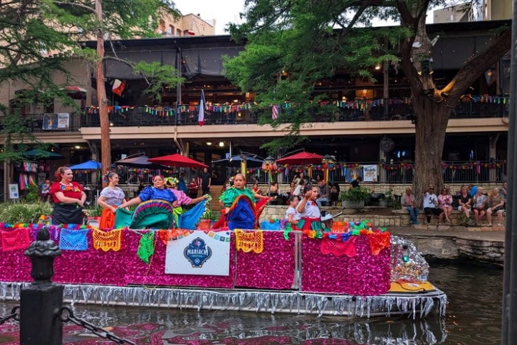A boatful of dancers and Mariachis parading along the River Walk during Fiesta