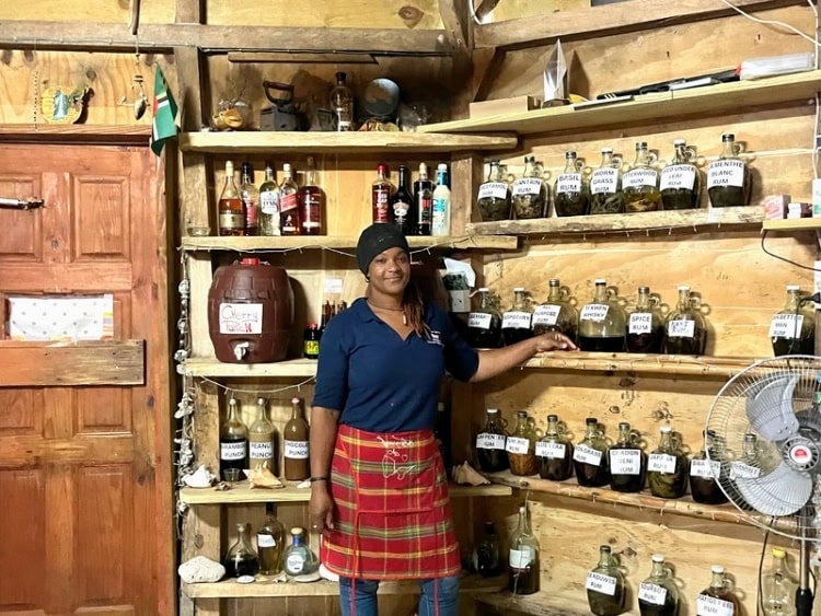 Woman at bush bar showing homemade rums
