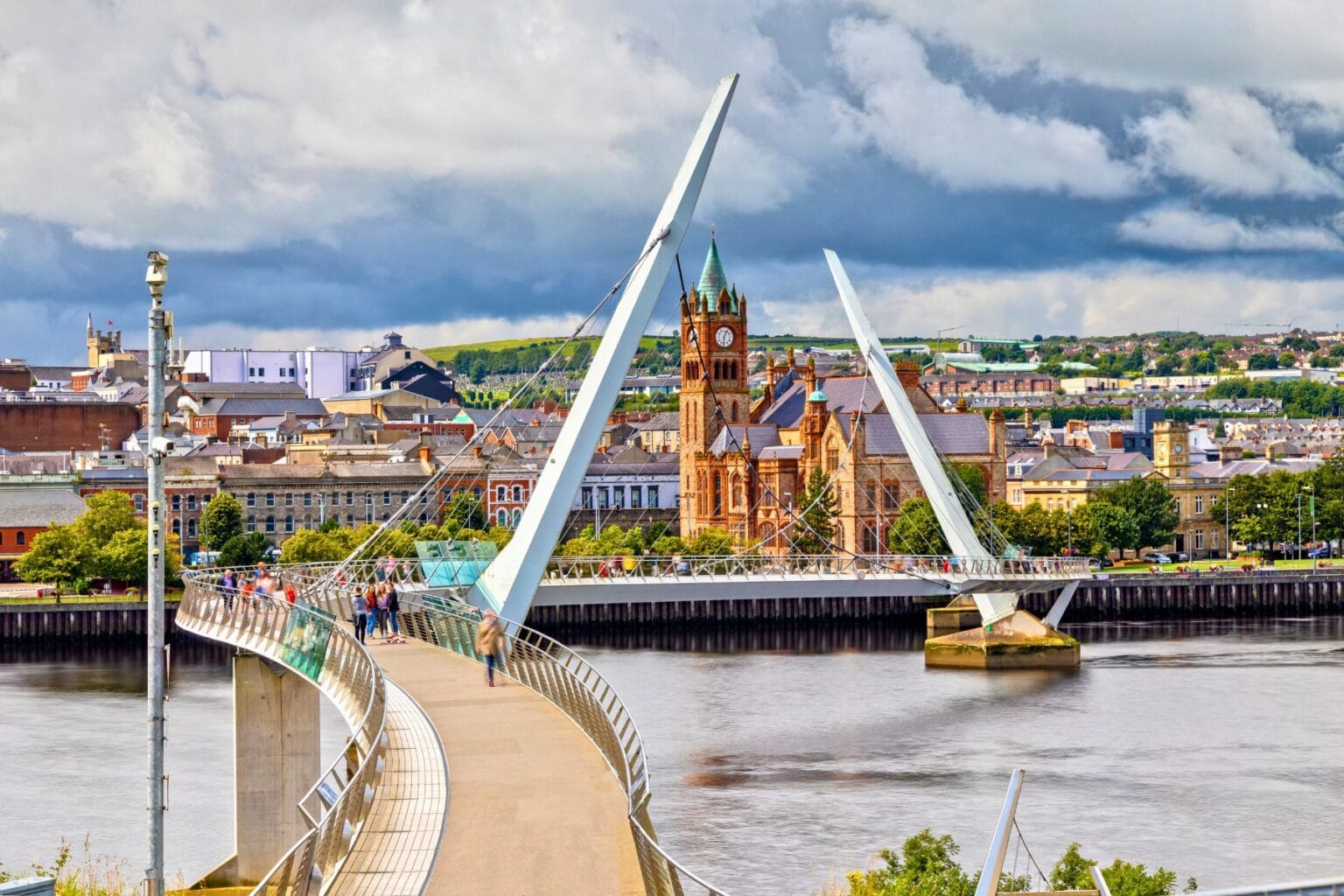 Derry's Peace Bridge spans the River Foyle, symbolizing Northern Ireland's journey from division to unity. Photo by by Susanne Neumann from Getty Images via Canva