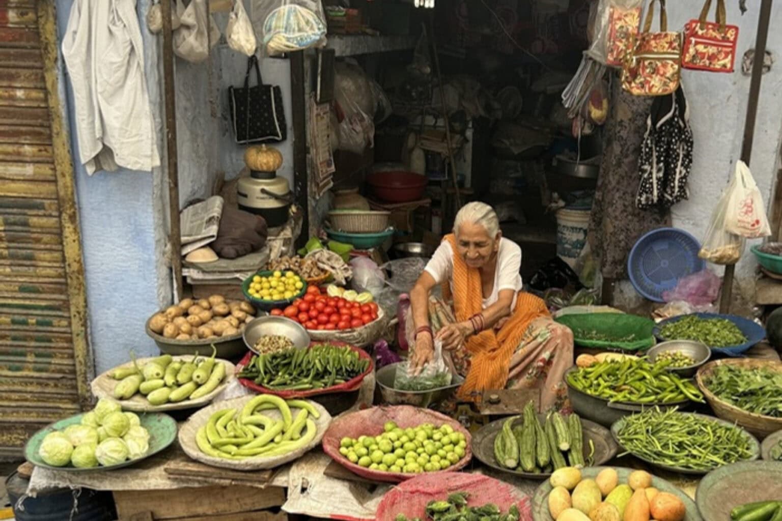 An 84-year-old woman, diligently selling fruit and vegetables, showcasing over 60 years of commitment to her trade with no retirement options.