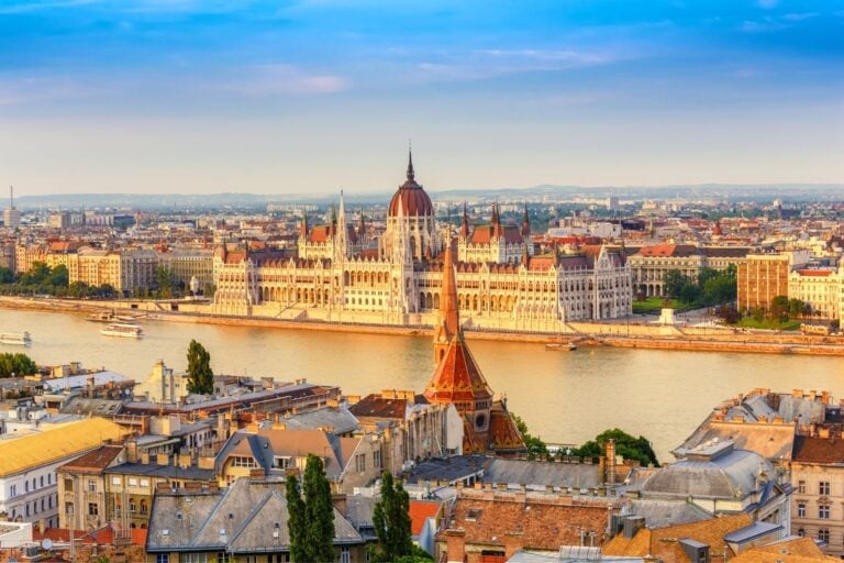 Budapest's Parliament Building and St. Stephen's Basilica overlook the Danube River in Hungary's vibrant capital. Image by Noppasin Wongchum from Getty Images via Canva